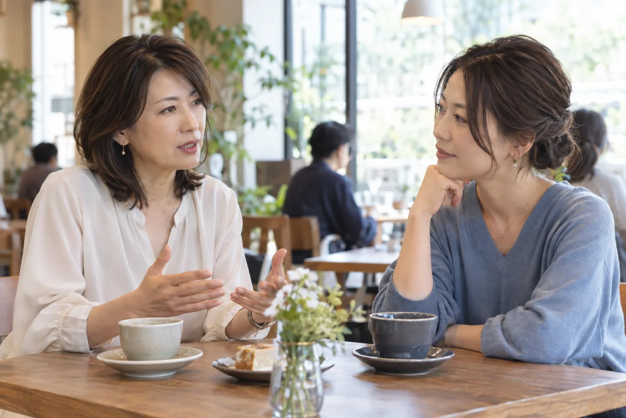 人間関係の疲れについて友人に落ち着いて相談する女性二人