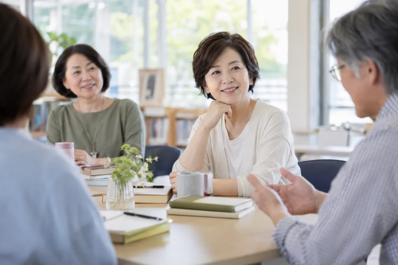 日本人女性が50代の参加者と趣味の絵画教室で活動している