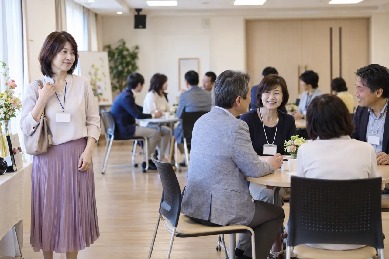 日本人の50代の参加者が交流会で適度な距離を保って会話している