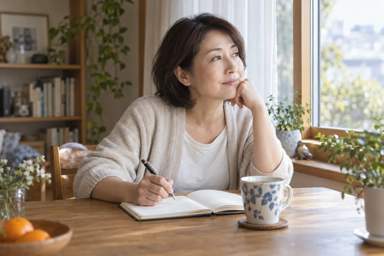 自宅で自分の気持ちをノートに書く日本人女性