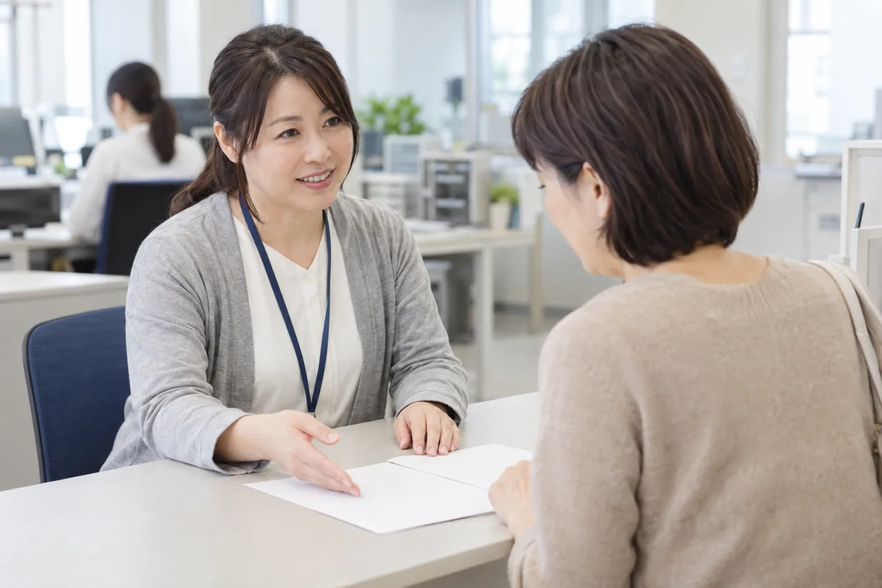 40代の女性が自治体の相談窓口で生活設計を相談する様子