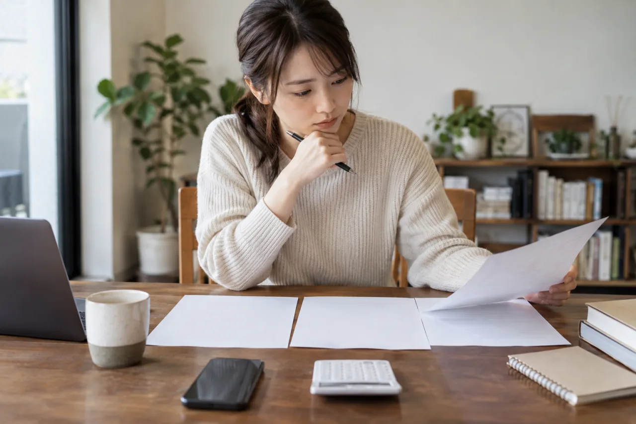 社会人が夜間のオンライン授業を受けながらノートを取る様子