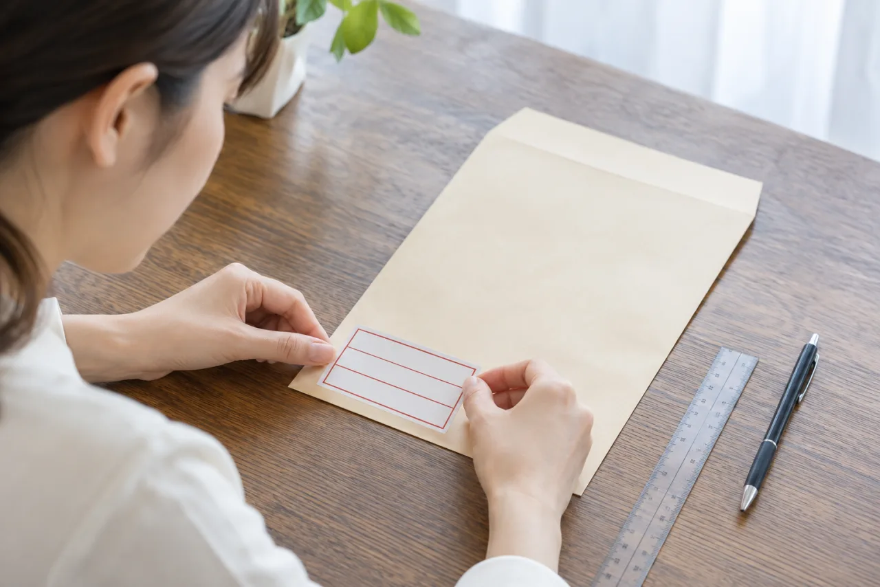 封筒の左下に応募書類の表示位置を合わせて確認する様子