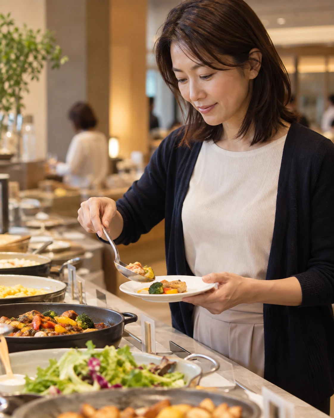 ビュッフェカウンターで食べ切れる少量を最初の皿に取る日本人女性