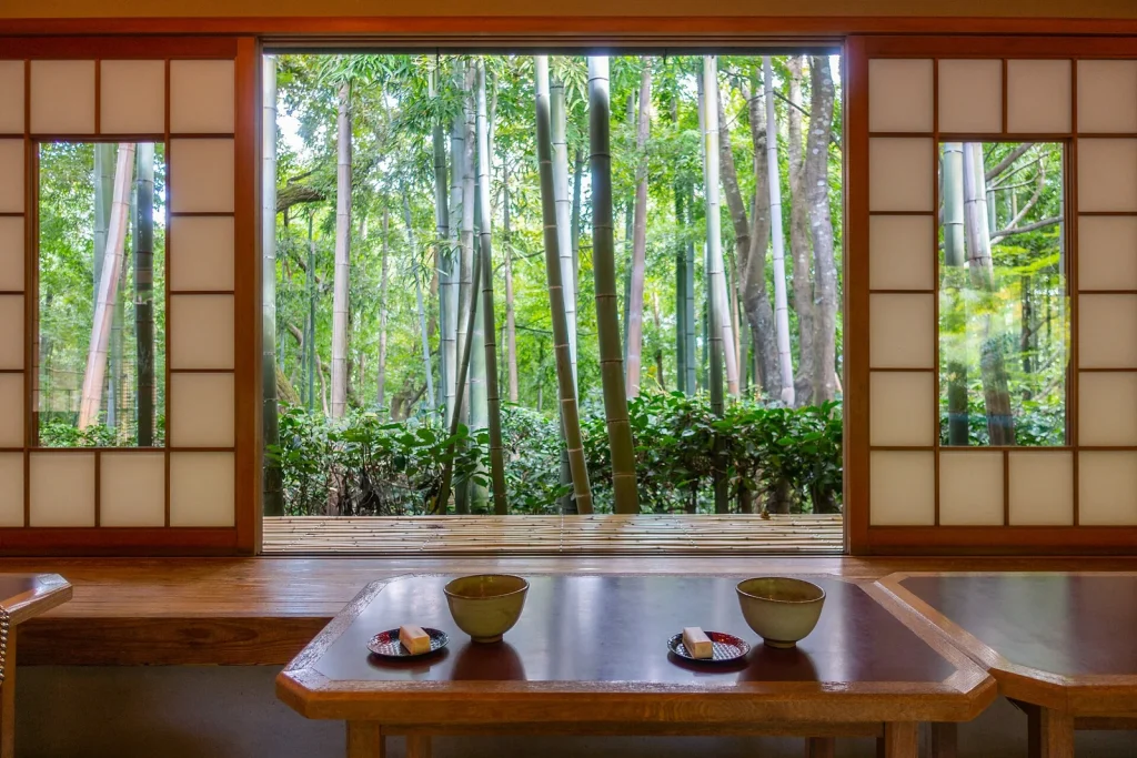 竹林を望む座敷の卓上に置かれた抹茶と菓子