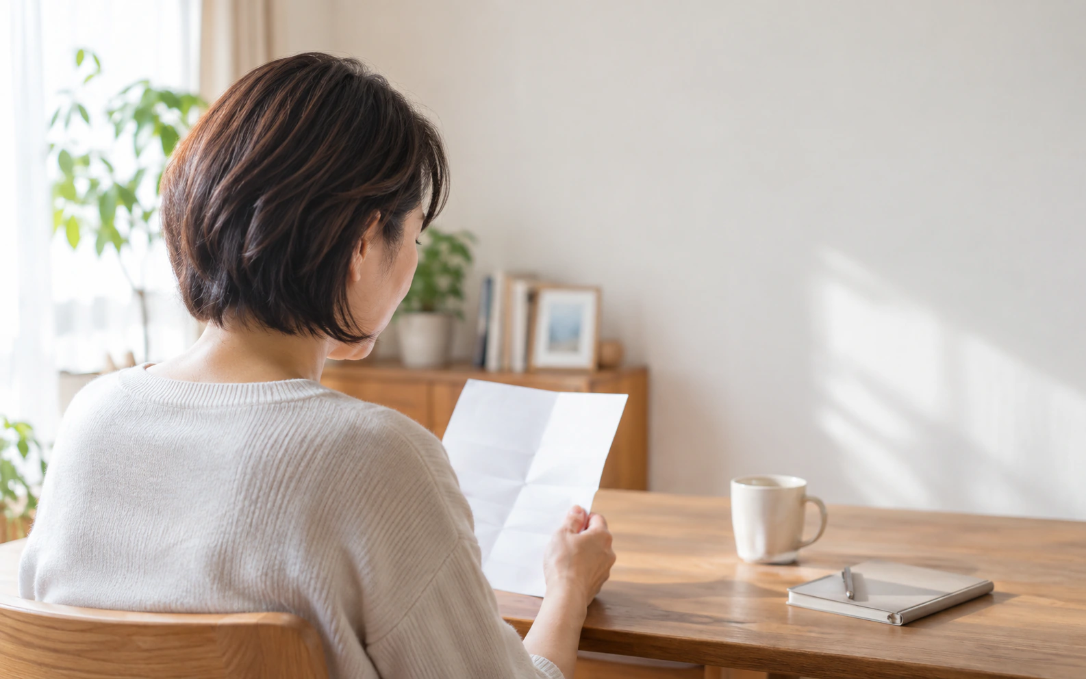 健診案内を手に、胃部X線検査の項目を確認する女性のイメージ