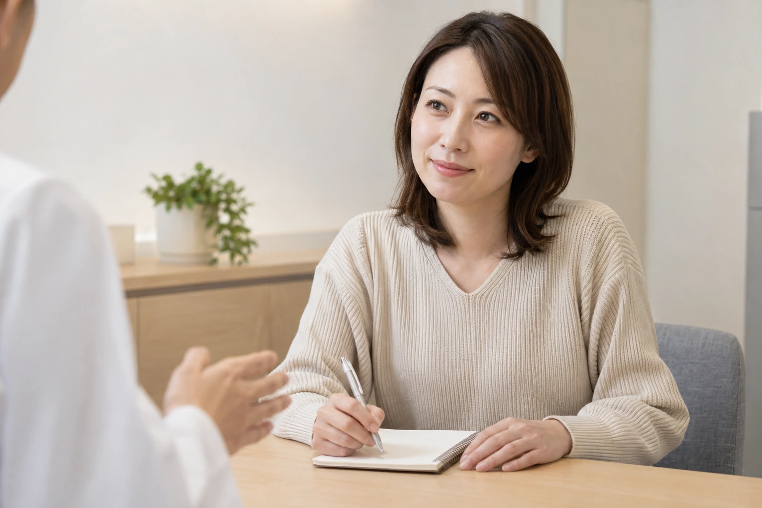 美容医療の相談で質問をノートに書く日本人女性