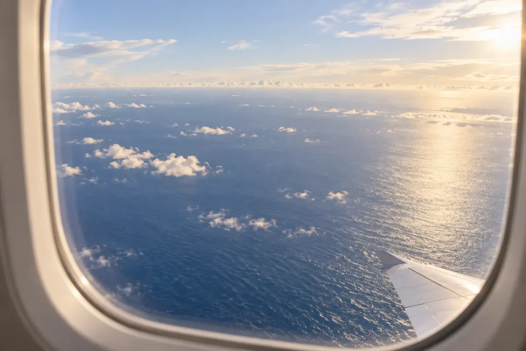 飛行機の窓から海と雲を眺める風景
