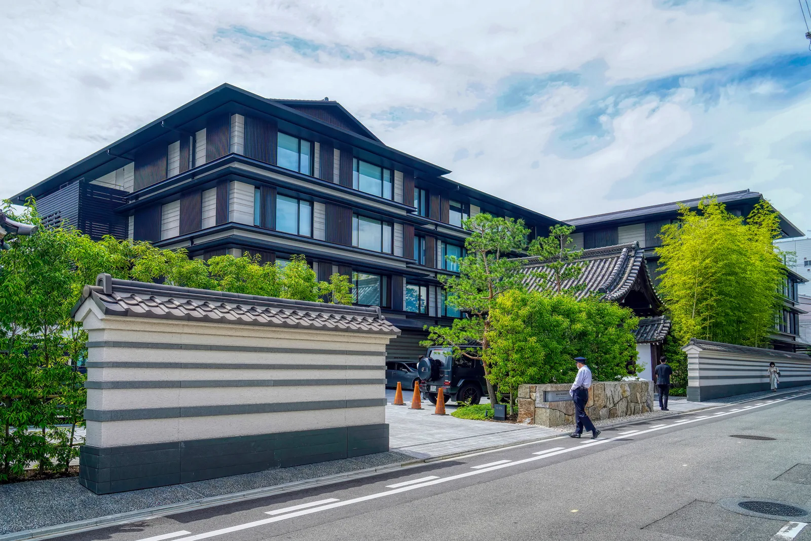 白い築地塀と梶井宮門の奥に見えるHOTEL THE MITSUI KYOTOの外観
