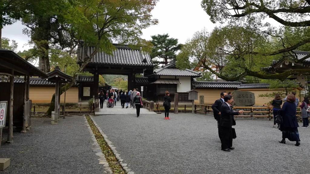 木々と築地塀の間に続く金閣寺総門への参道