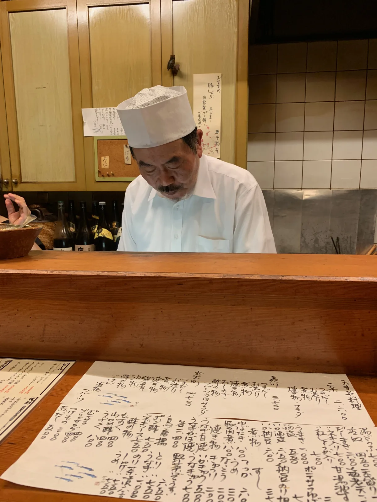 京都の小さな料理店でカウンター越しに調理する料理人