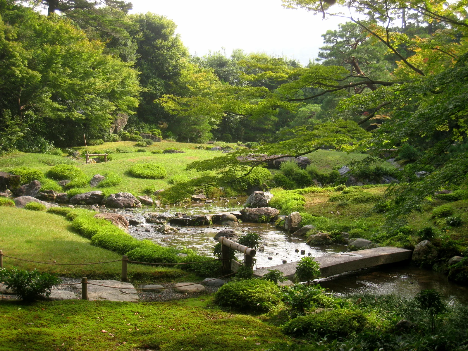 東山の緑を背景に小川が流れる京都・無鄰菴の庭園