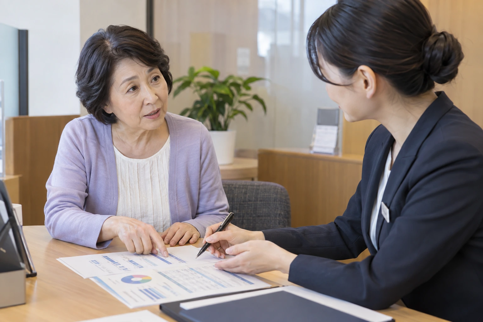 年金の資料と通帳を見比べる60代女性