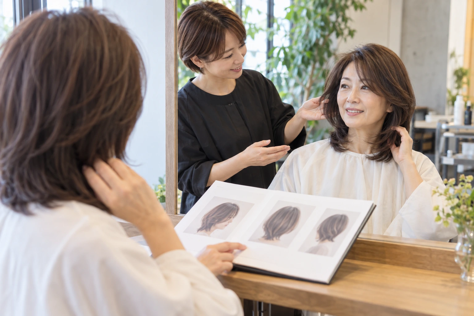 鏡の前で髪の横側を確認する50代の女性