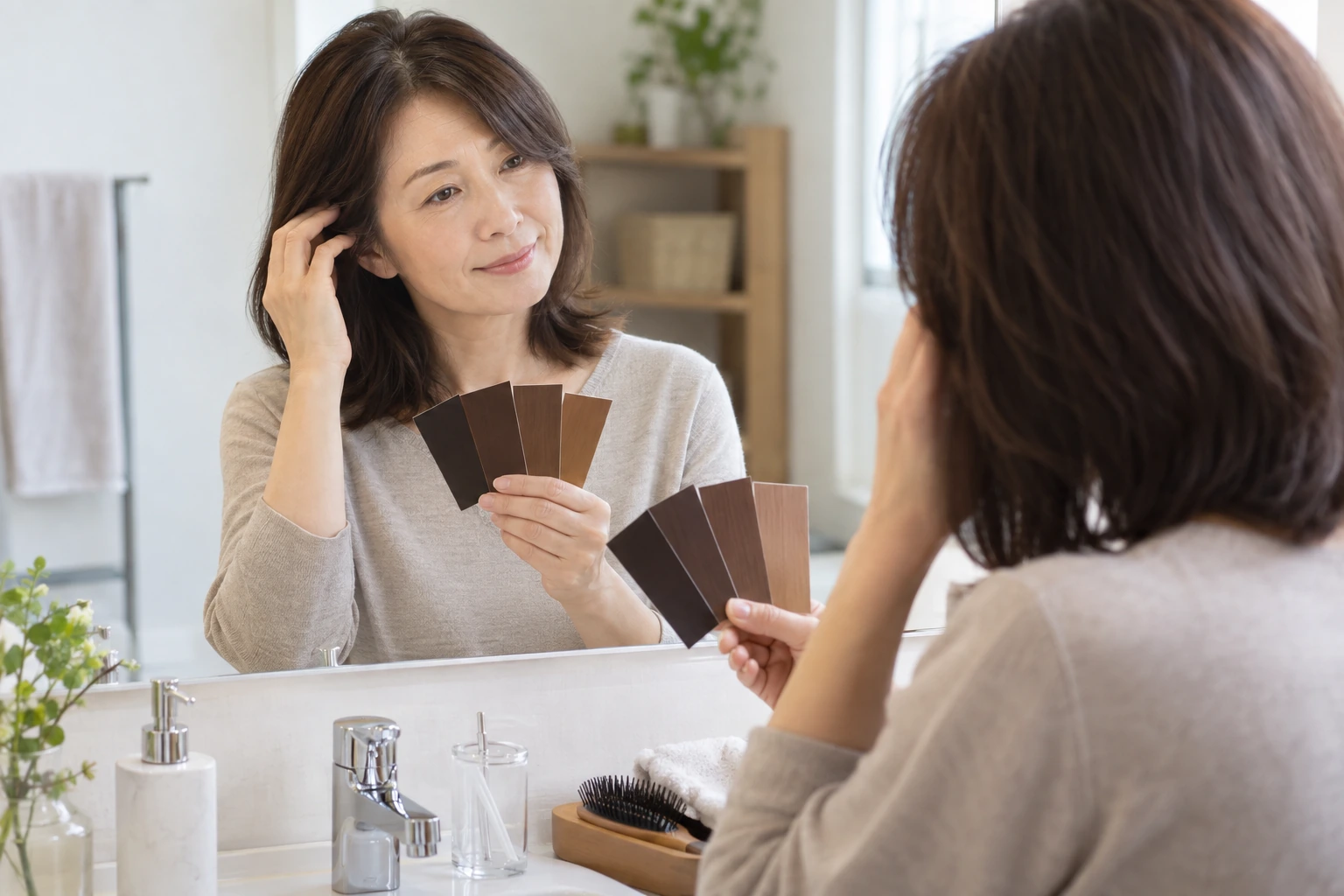 後頭部の髪をそっと確認しながらノートに記録する女性