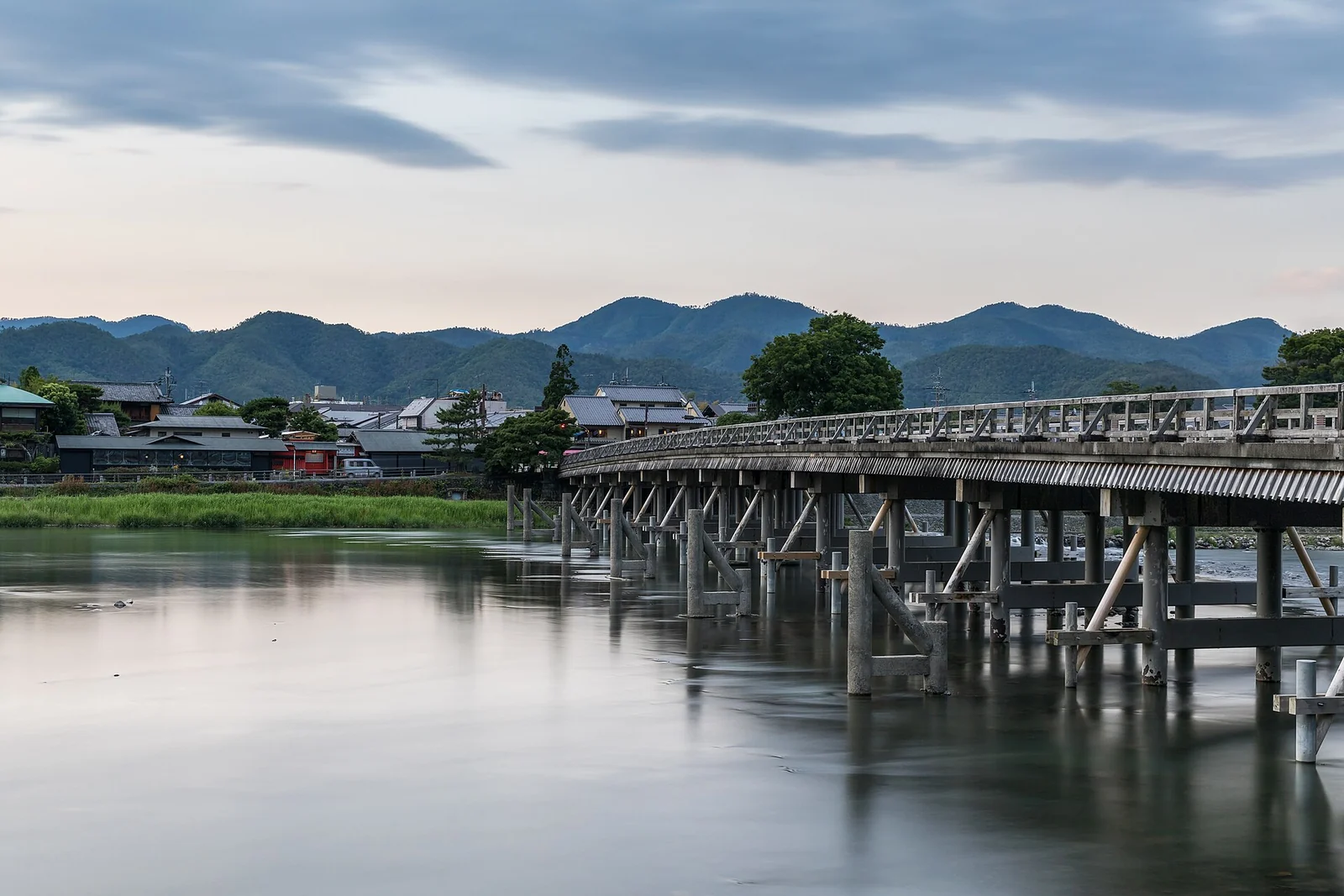 夕方の静かな川面に架かる嵐山の渡月橋