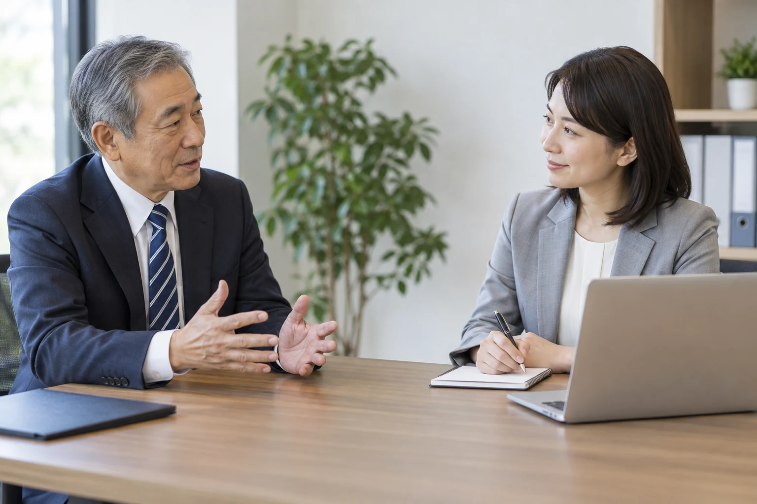 再雇用後の条件を会社の担当者に相談する日本人男性