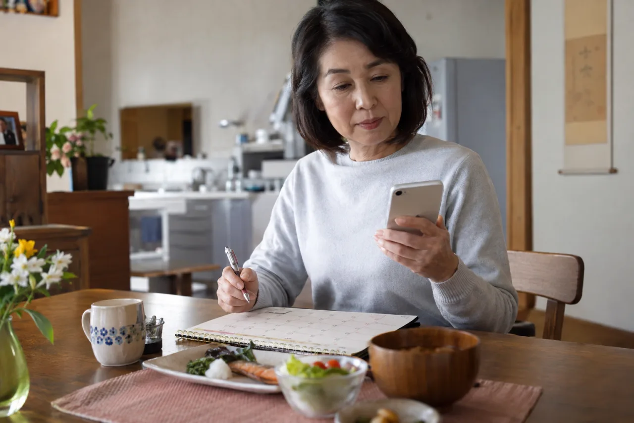 60代の男性が自宅でオンライン相談を受けながら定年後の働き方をメモしている様子
