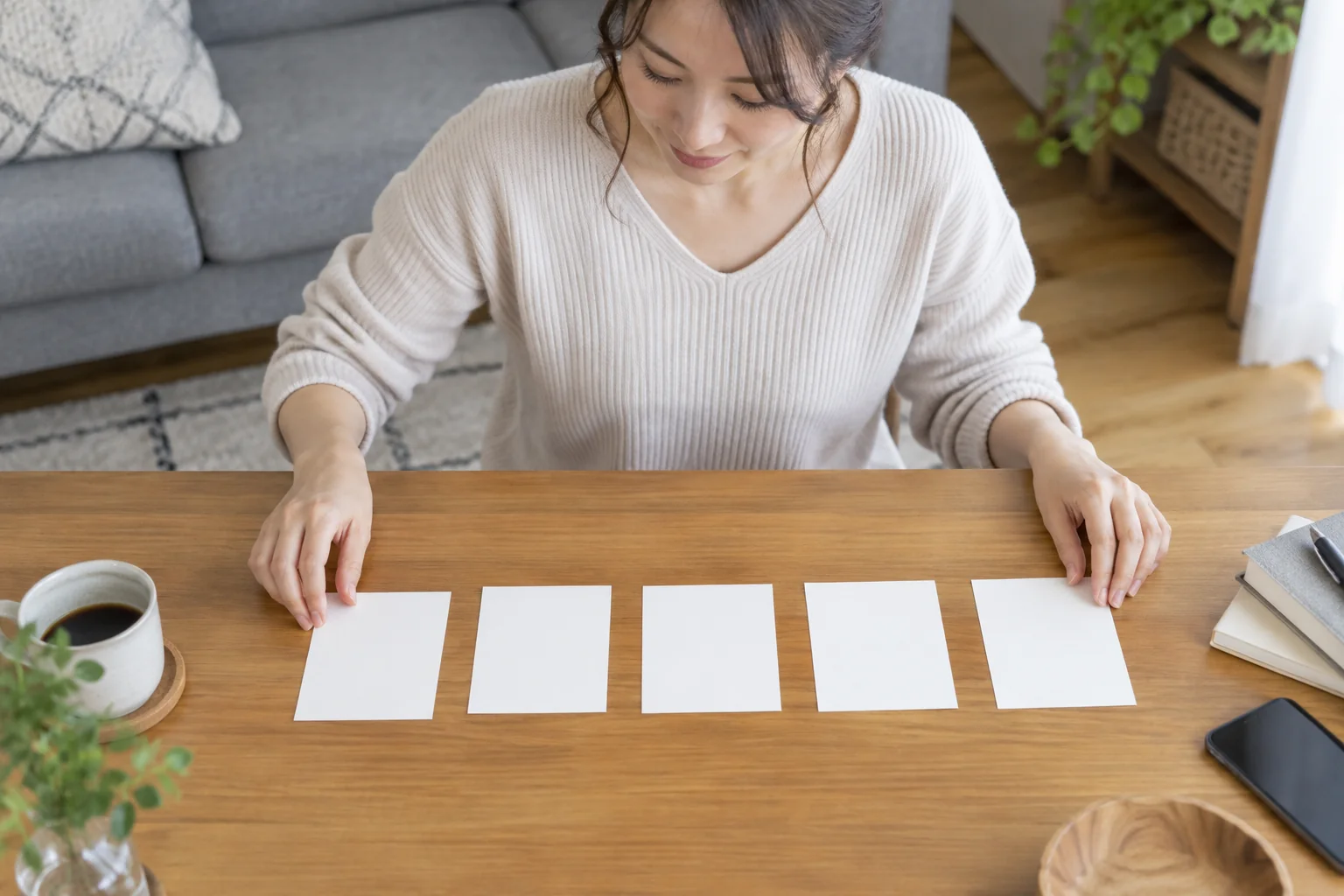 五つの費用項目を別々のカードに分けて確認する日本人女性の再現イメージ