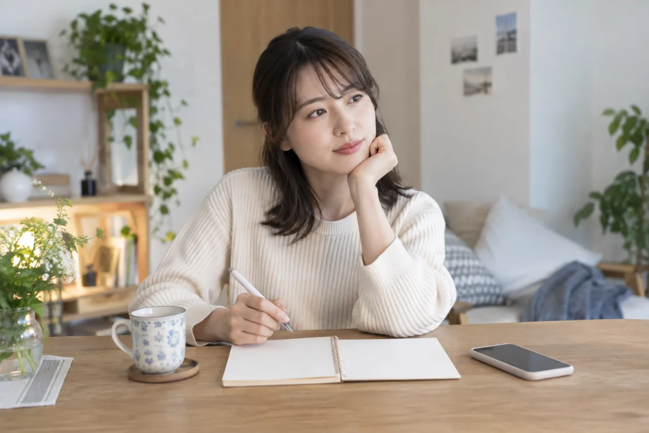 一人暮らしの日本人女性が自宅で結婚相談所を利用するか考えている場面