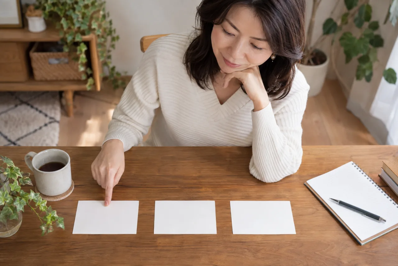 日本人女性が年齢や距離や連絡頻度などの条件カードを並べて比較している様子