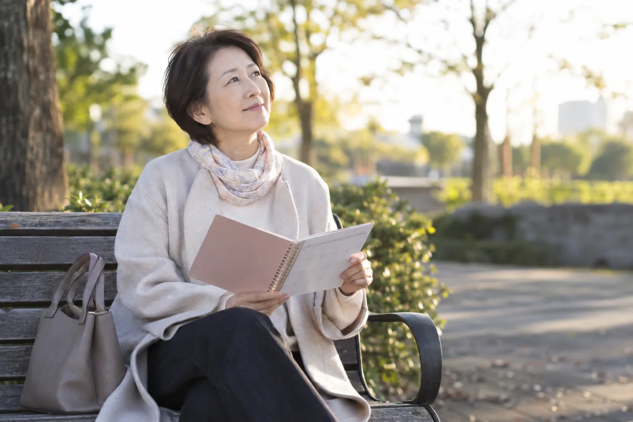 婚活後に公園で気持ちを整える60代の日本人女性