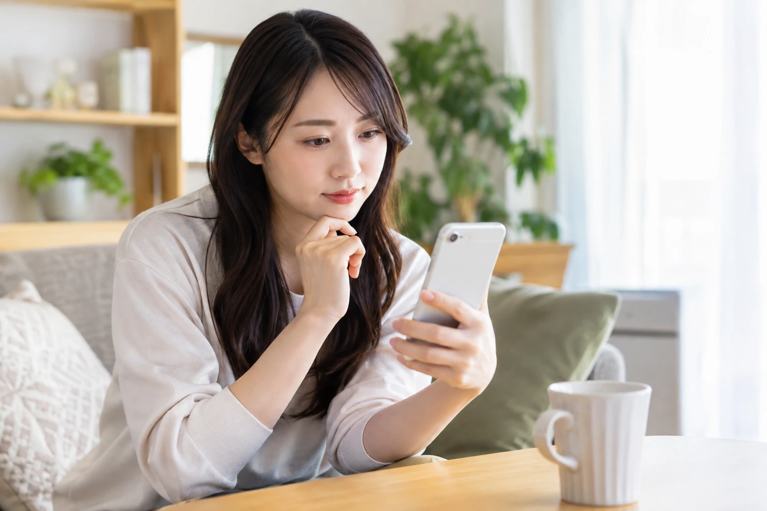 日本人の20代女性が婚活イベントの参加条件をスマートフォンで確認する様子