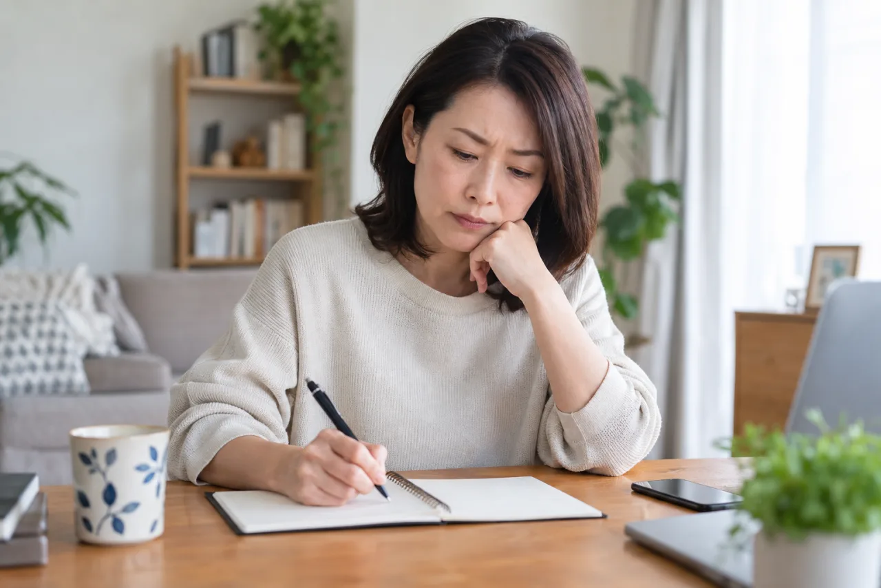 転職するか迷いながら条件を書き出す日本人女性