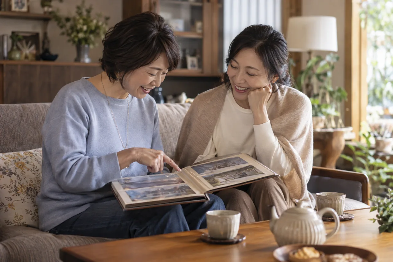 日本人女性が花束と白いカードを前に誕生日メッセージを書いている様子