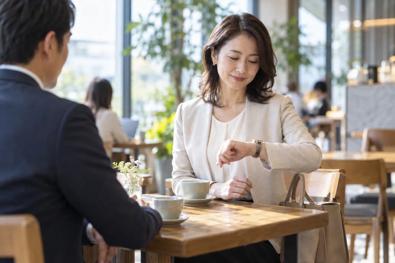 初対面の場で時間を確認する女性