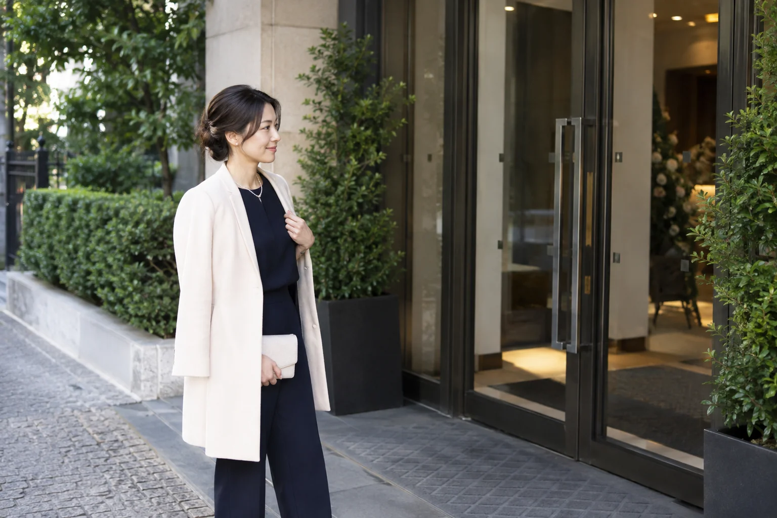会場の入口で立ち止まり、受付場所を確認する女性