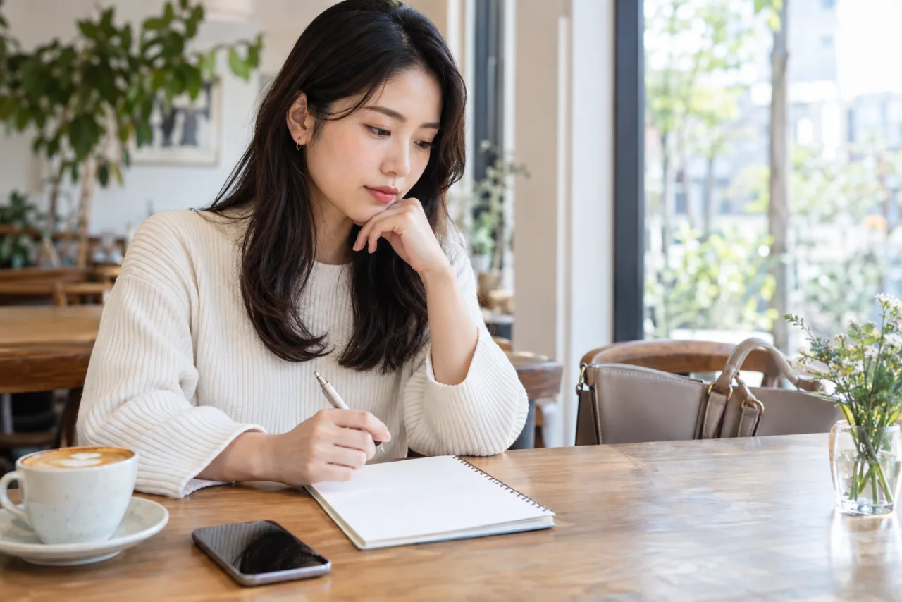 日本人の女性が昼間のカフェで初対面の安全計画を確認する