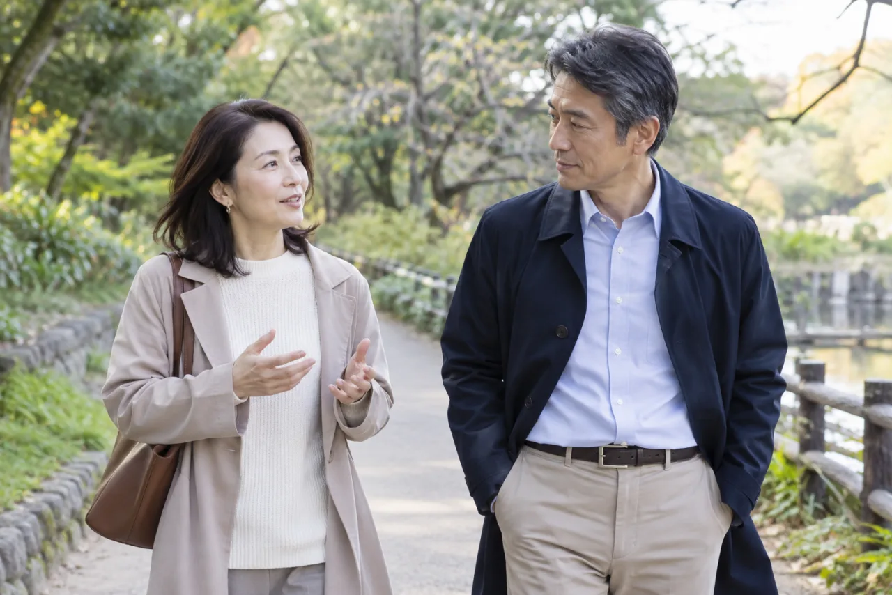 公園を歩きながら将来の距離感を話す日本人の男女
