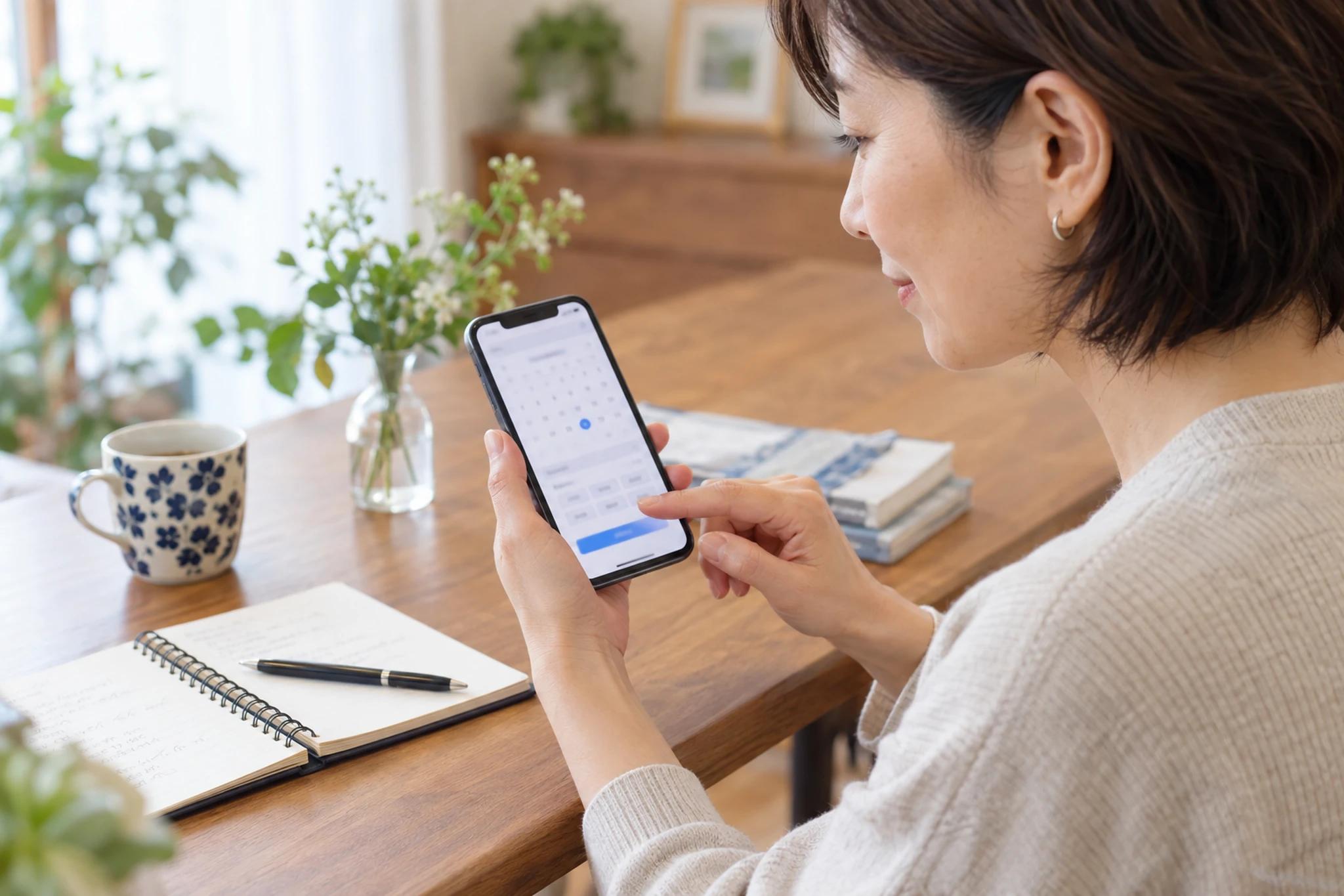 スマートフォンで予約日時を確認する女性