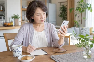 不審な通知を確認する一人暮らしの女性
