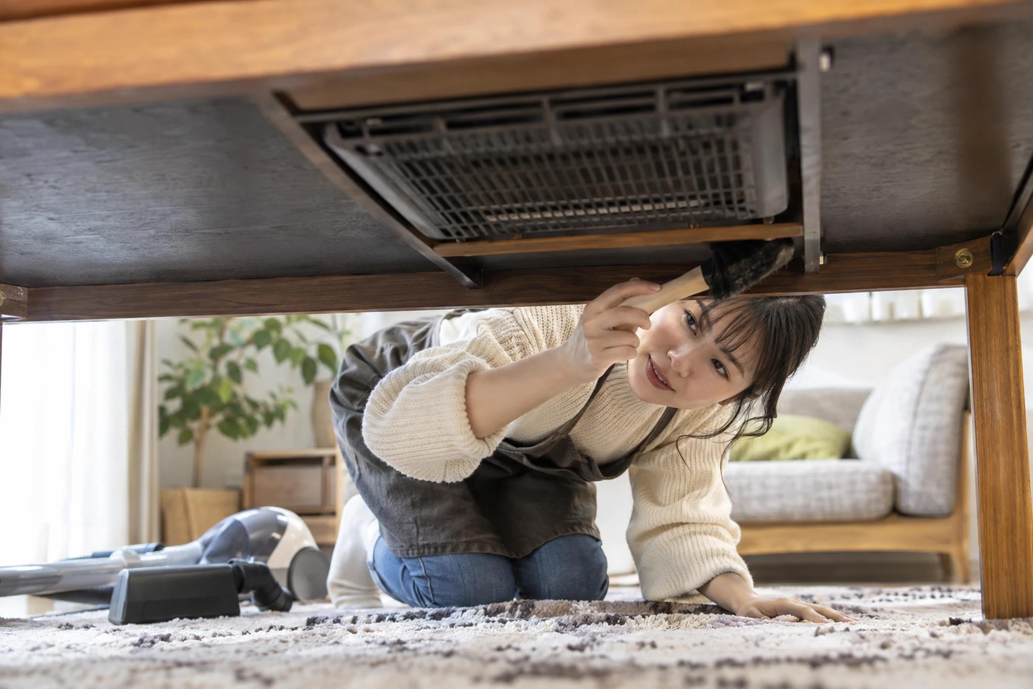 電源を切ったこたつのヒーター周りを掃除する女性