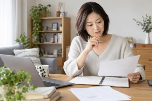 勤務カレンダーと書類を確認する日本人女性