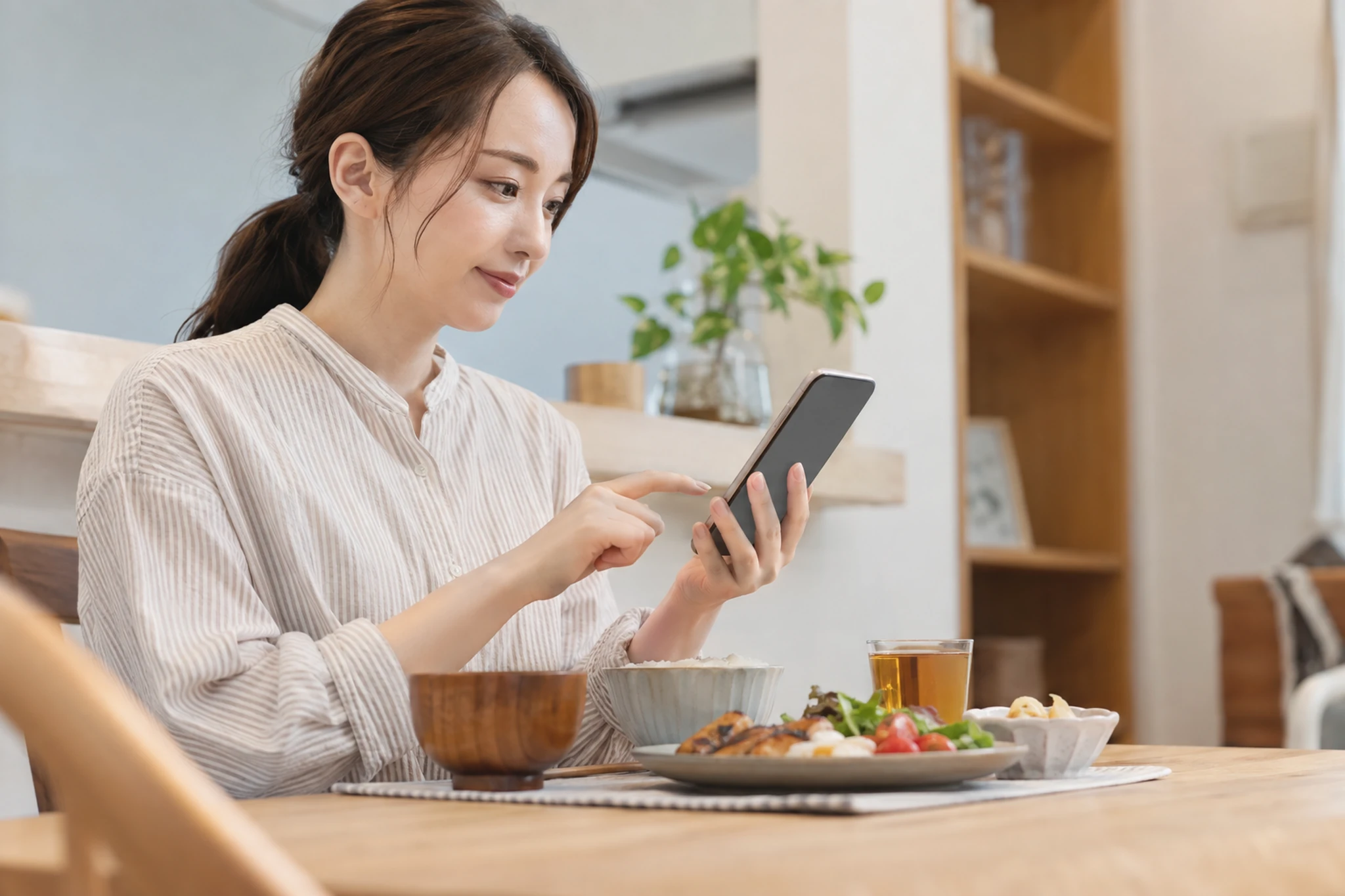 一週間の食事記録を見返しながら予定を立てる女性