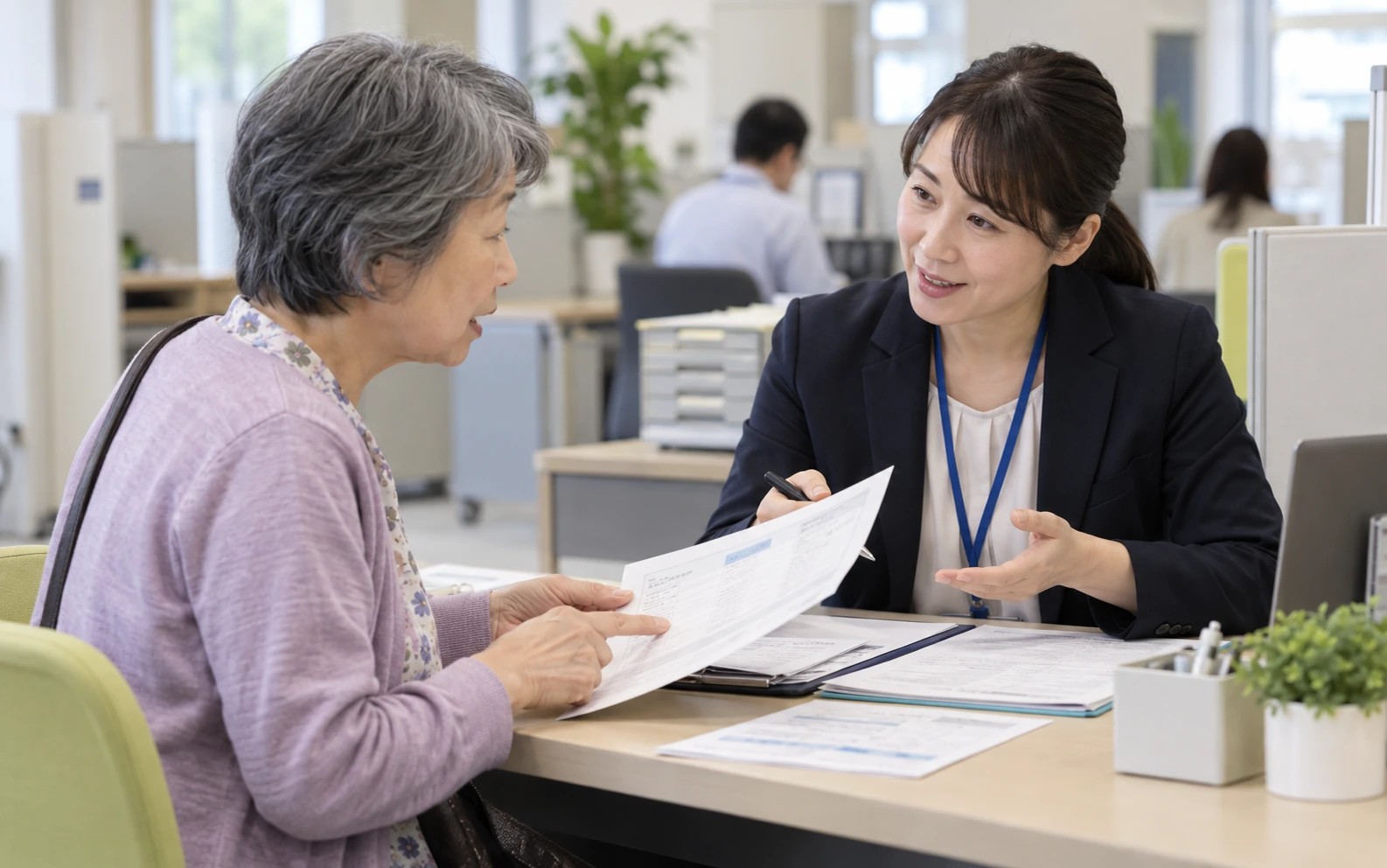 年金の開始時期について窓口で相談する女性