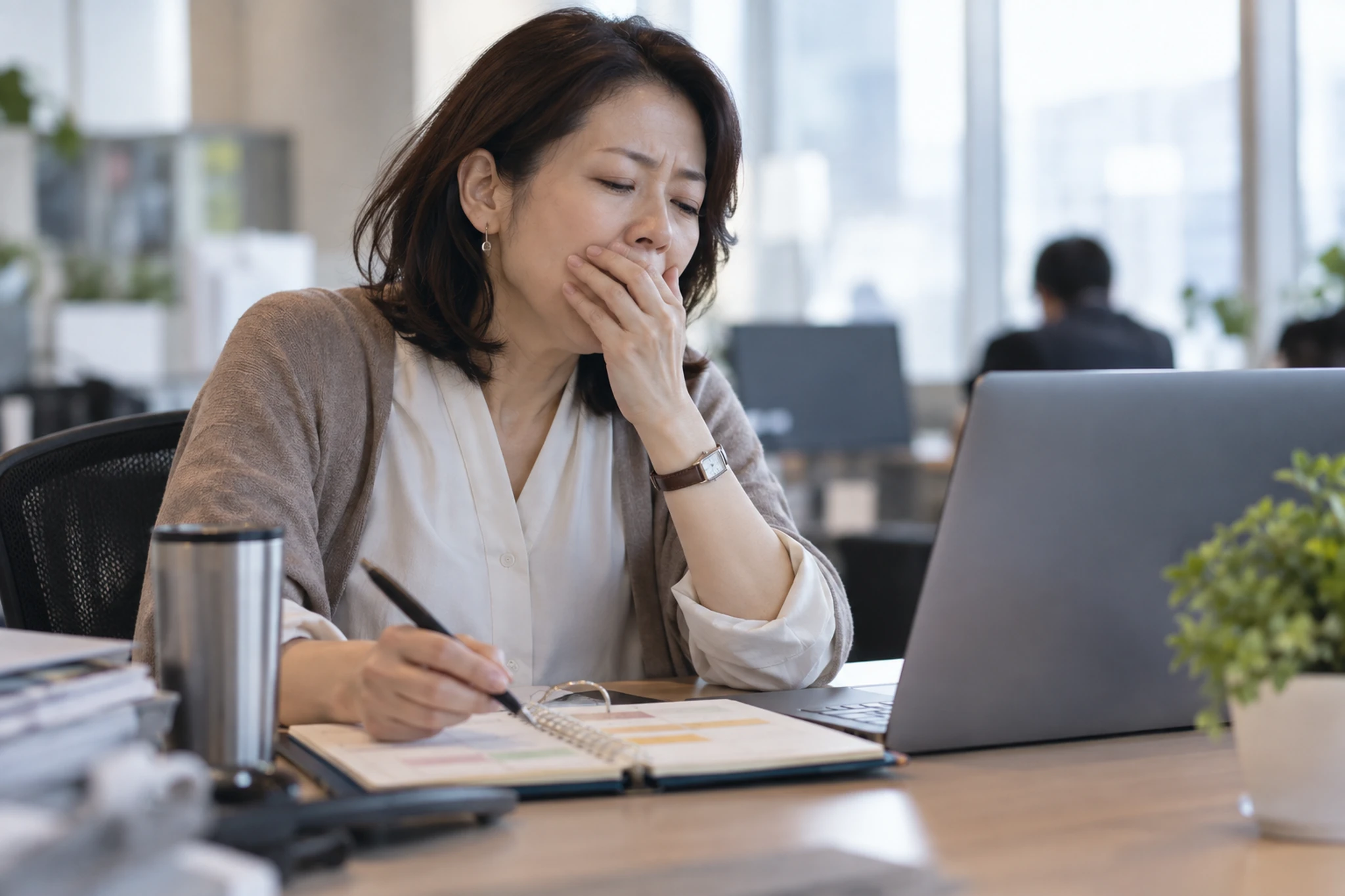 職場で体調を見ながら予定を調整する女性