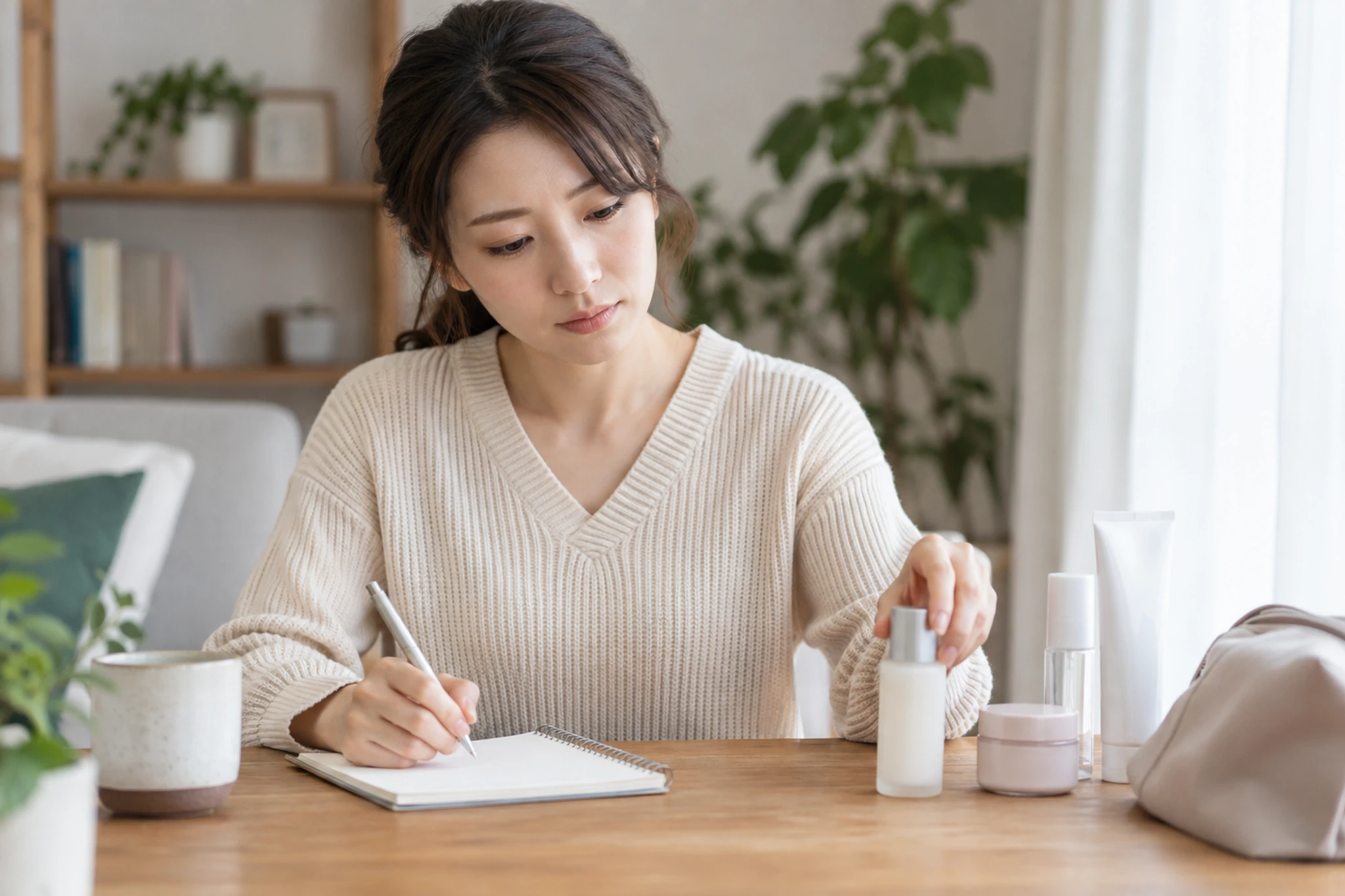 肌に合わない化粧品をいったん外し相談内容をメモする女性