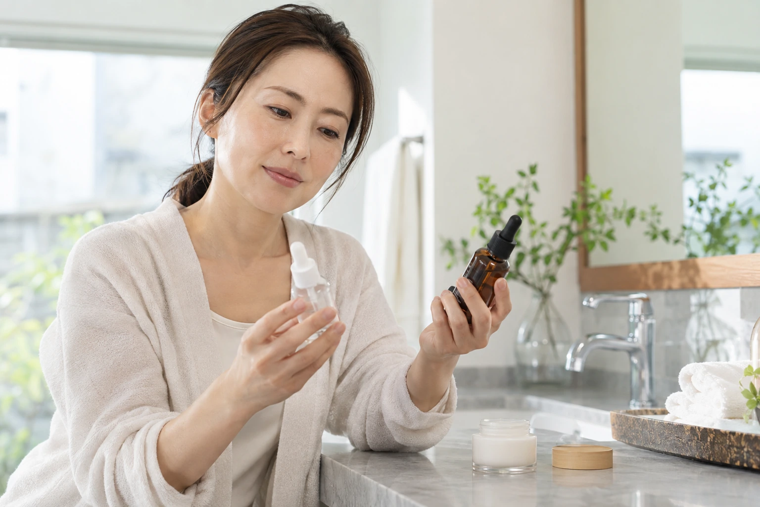 美容液の容器と表示を確認する手元