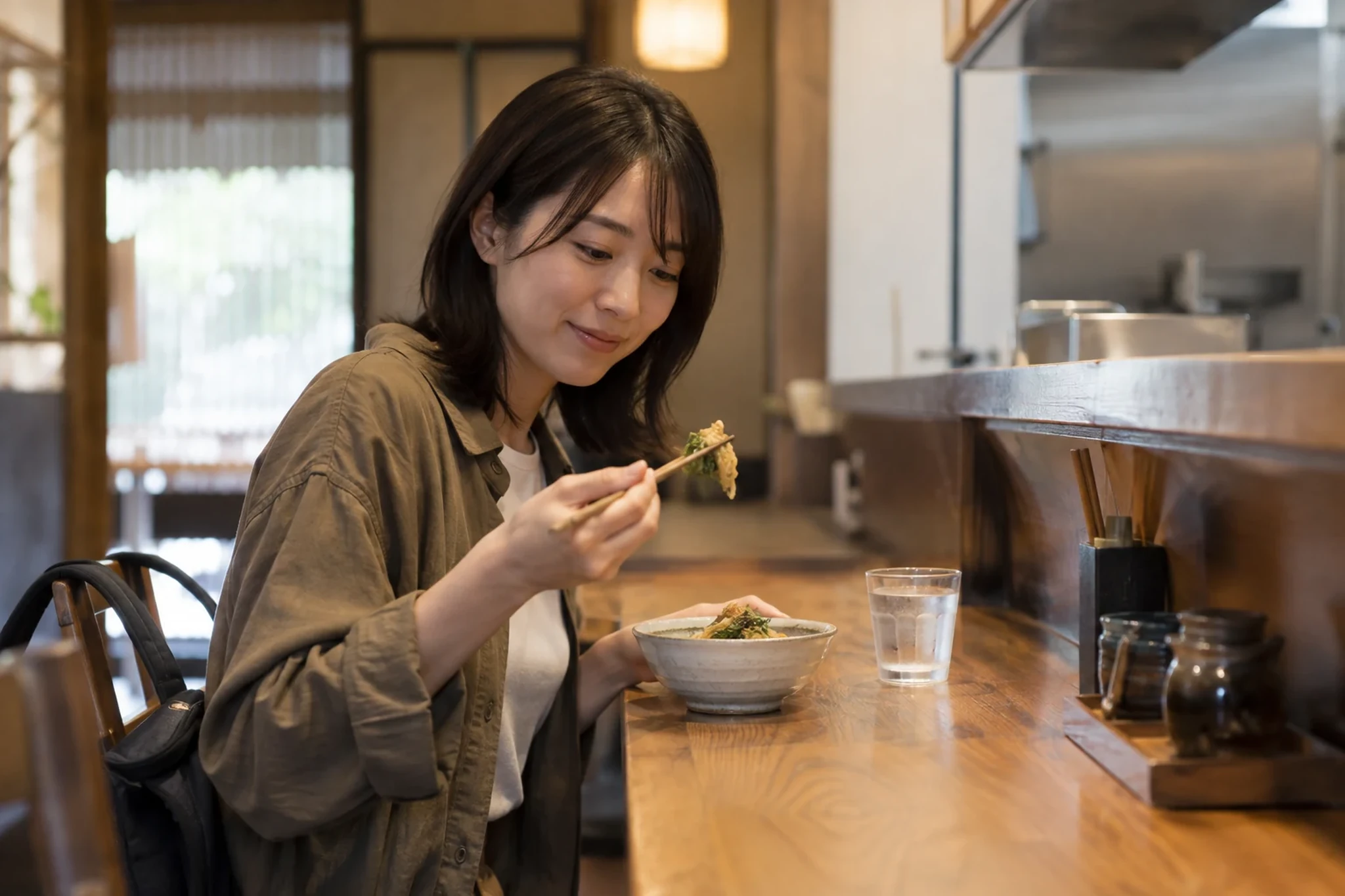 カウンターで一人で食事する女性