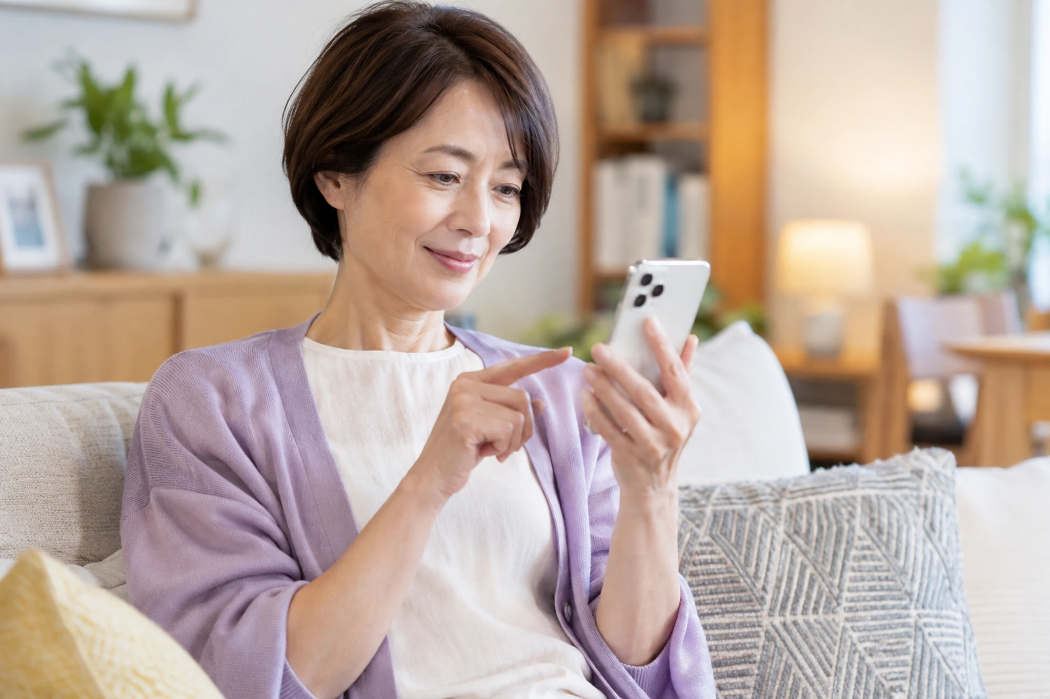 スマートフォンで安否確認を確認する一人暮らしの女性