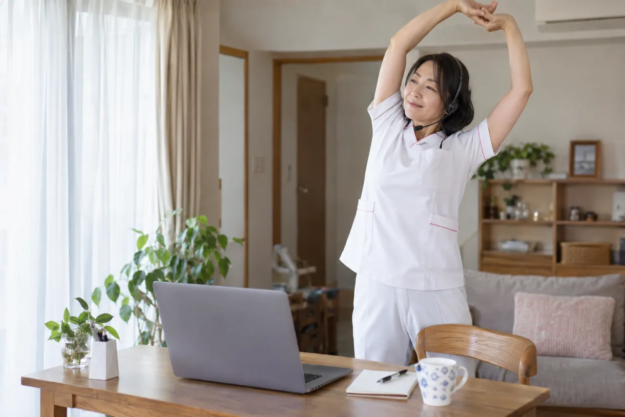看護師が自宅でオンライン面接に向けてカメラと照明を調整している様子