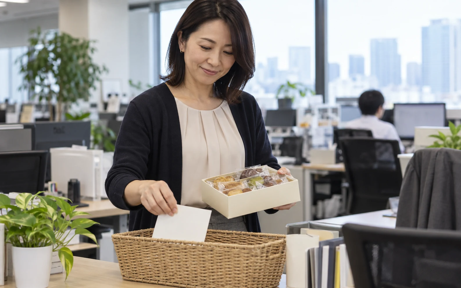 退職のお菓子に短いメッセージを添えて準備する日本人女性