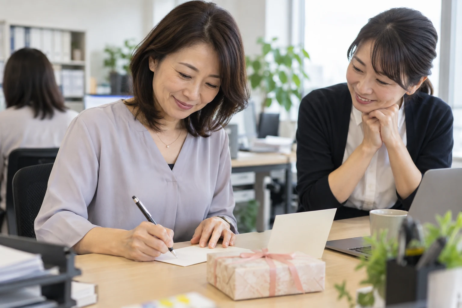 日本人女性が親しい同僚へ退職カードを書く