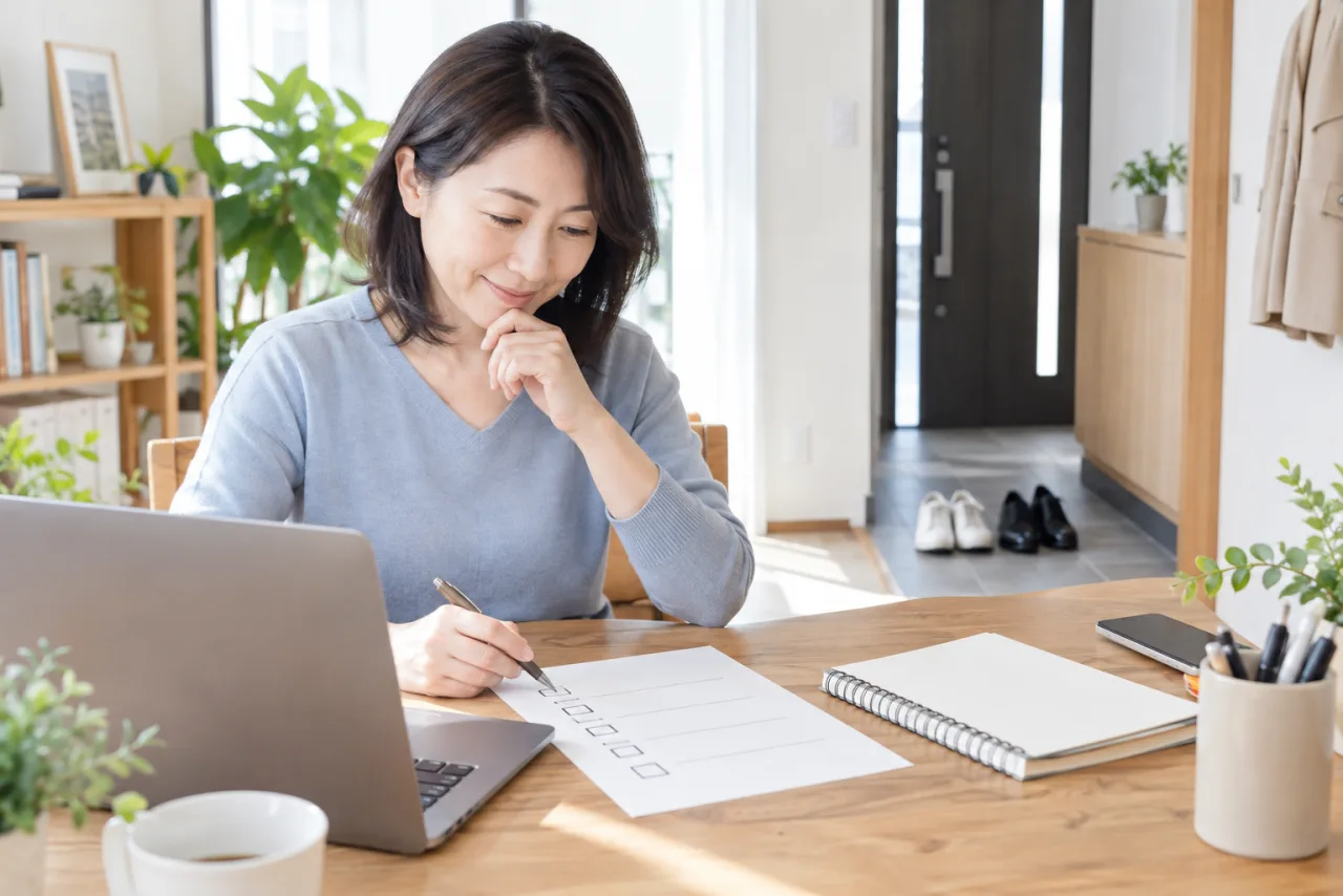 日本人女性が生活費と失業給付の見込みをノートに整理している