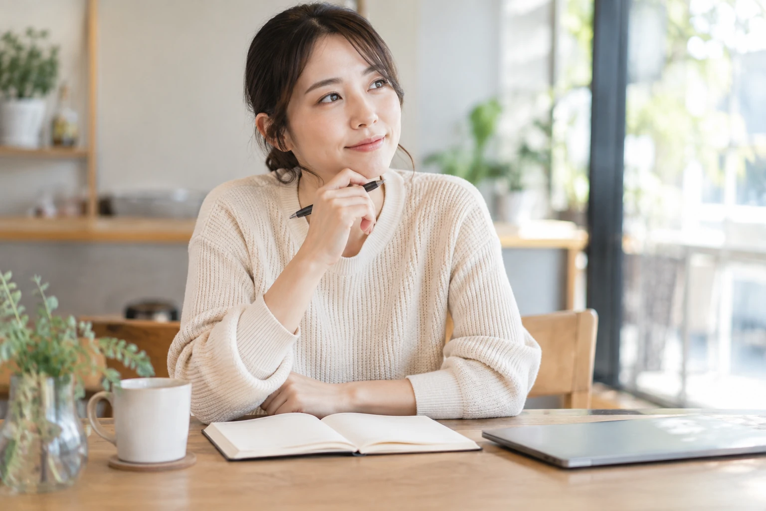 オンライン講座で学んだ内容を振り返ってノートに整理する女性
