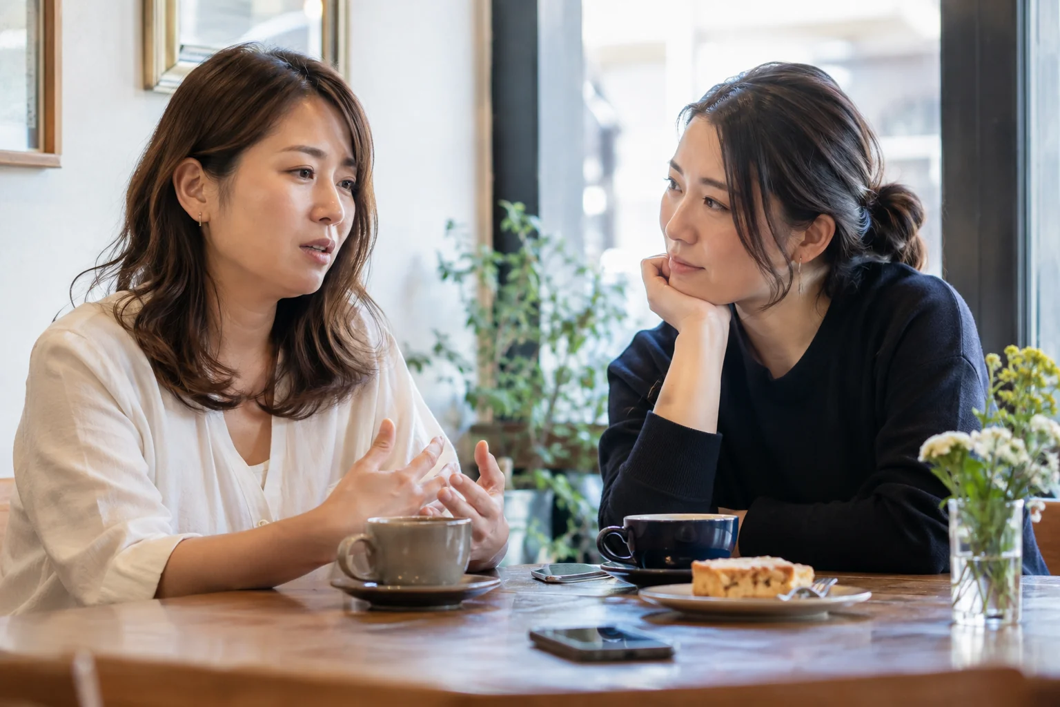 日本人女性二人がカフェで静かに話す